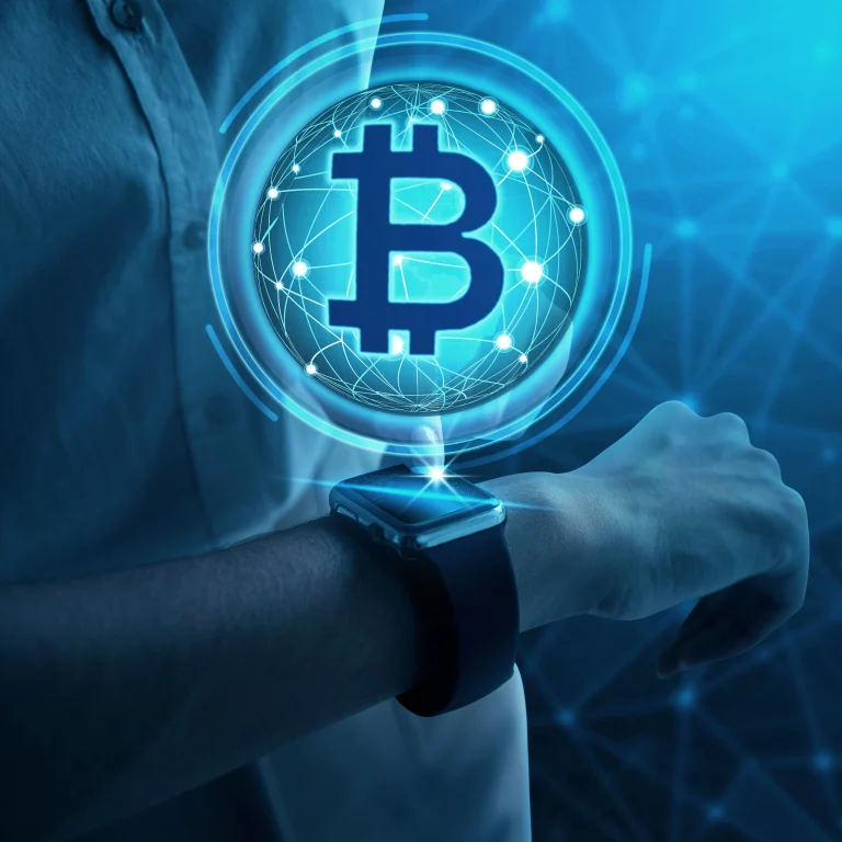 Hand wearing smartwatch with Bitcoin symbol above it.